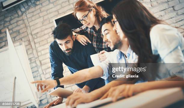 it experts working on a computer. - programming team stock pictures, royalty-free photos & images