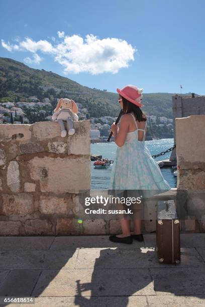 young girl playing a recorder concert for her stuffed bunny - ardia stock-fotos und bilder