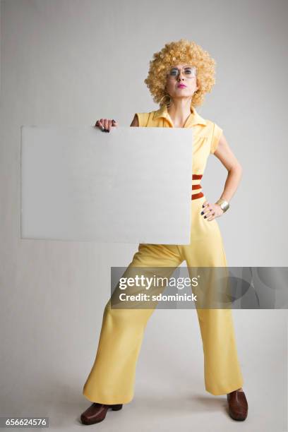 woman with weird 70's look holding blank sign - disco costume stock pictures, royalty-free photos & images