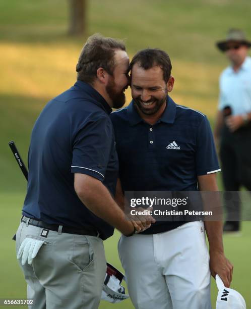 Shane Lowry of Ireland shakes hands with Sergio Garcia of Spain after they halved their match during round one of the World Golf Championships-Dell...