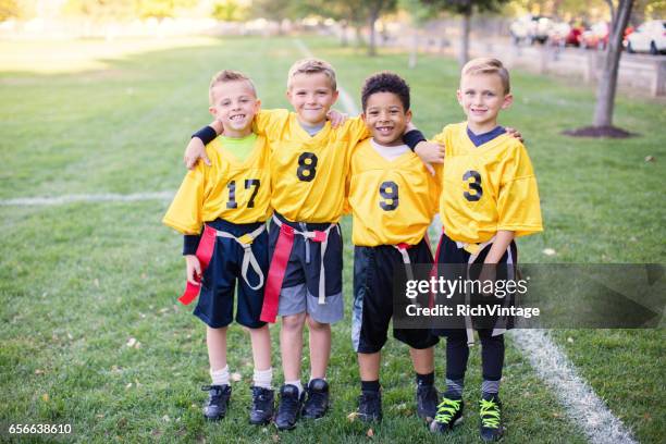 four young boys and teammates play flag football - flag football stock pictures, royalty-free photos & images