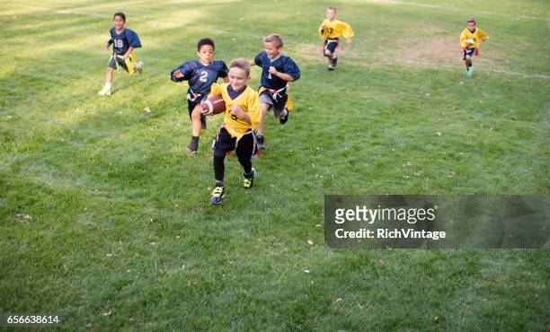 young boy flag football player running for a touchdown - rush american football stock pictures, royalty-free photos & images