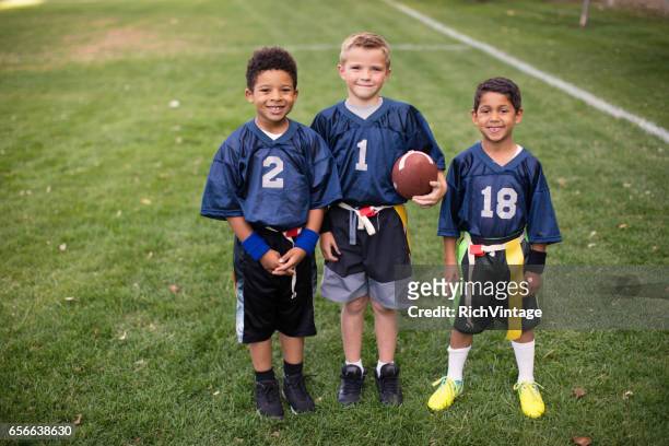 three young boys and teammates play flag football - flag football stock pictures, royalty-free photos & images