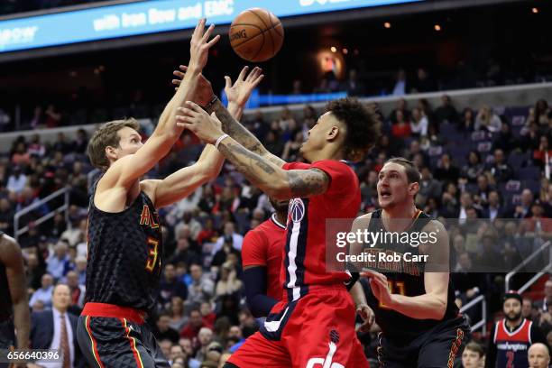 Mike Dunleavy of the Atlanta Hawks and Kelly Oubre Jr. #12 of the Washington Wizards go up for a loose ball in the first half at Verizon Center on...