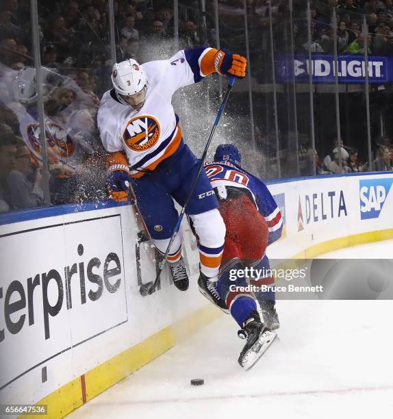 Travis Hamonic of the New York Islanders jumps to avoid a hit from Chris Kreider of the New York Rangers during the second period at Madison Square...