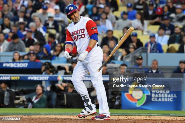 Carlos Beltran of team Puerto Rico tosses his bat after walking in the second inning against team United States during Game 3 of the Championship...