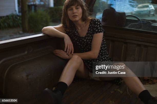 woman sitting in the back of a pick up truck showcasing her underwear - jambes écartées photos et images de collection
