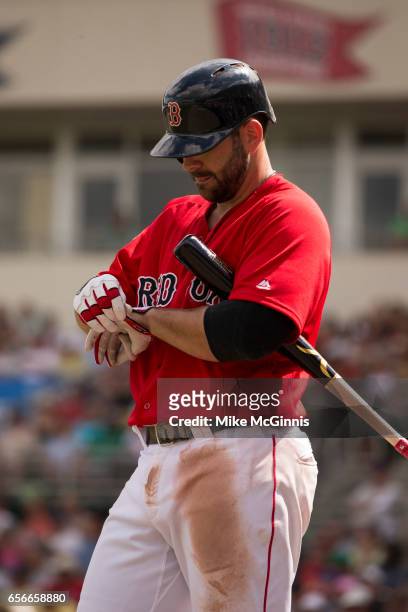 Mitch Moreland of the Boston Red Sox tightens his Franklin batting gloves during the spring Training game against the Team USA at Jet Blu Park on...