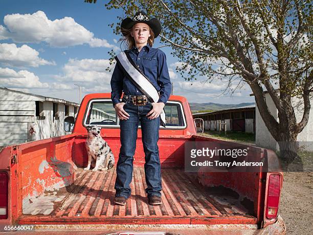 young cowgirl standing in pickup truck with dog - sash fotografías e imágenes de stock