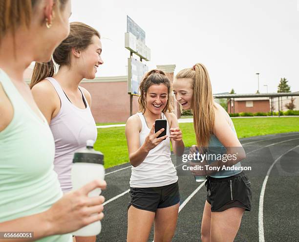 young women runners checking phone on school track - girl in tank top stock pictures, royalty-free photos & images