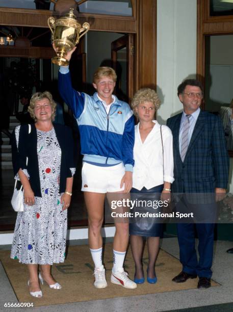 Boris Becker of West Germany holds aloft the trophy, surrounded by his family, after defeating Ivan Lendl of Czechoslovakia on Centre Court during...