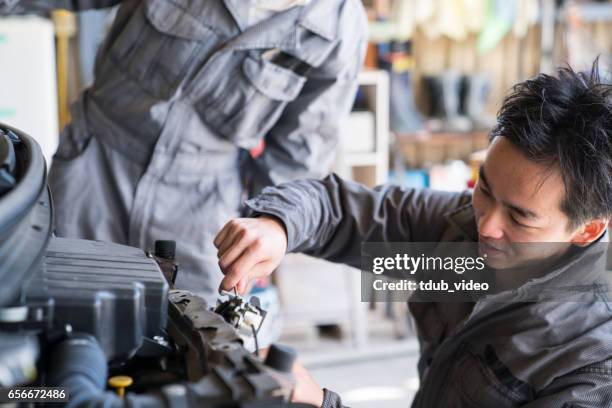 自動車修理工場で一緒に働く 2 つの力学 - repairing ストックフォトと画像