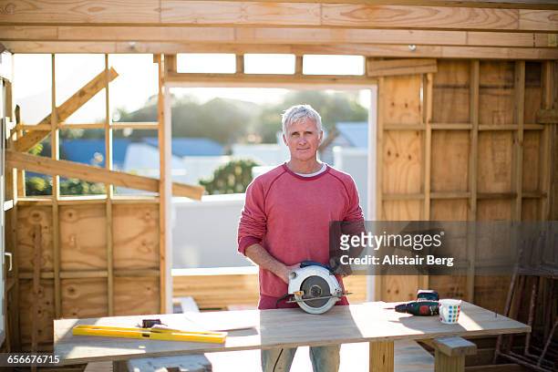 builder working on a wood framed house - wood worker posing ストックフォトと画像