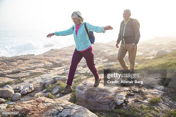 senior couple walking outdoors together - active senior man stock-fotos und bilder