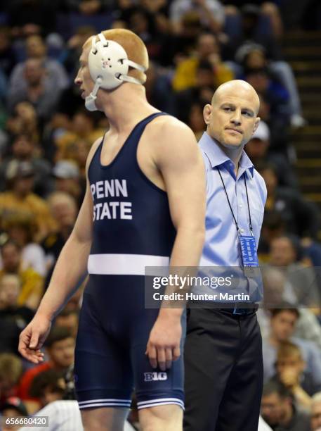 Bo Nickal of the Penn State Nittany Lions stands with head coach Cael Sanderson during the championship finals of the NCAA Wrestling Championships on...
