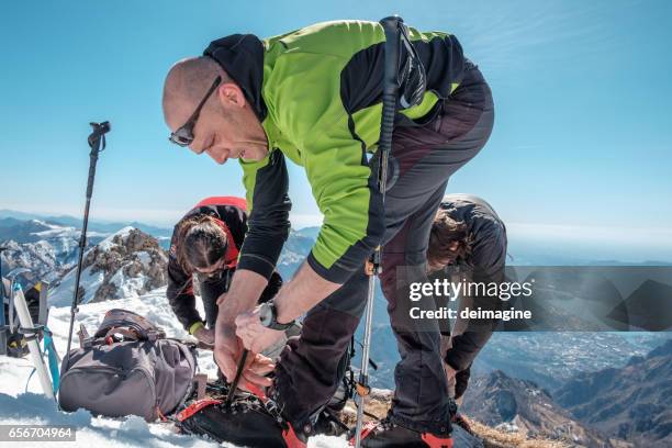 climbers on the mountain top fasten crampon - crampon stock pictures, royalty-free photos & images