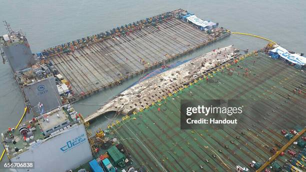 In this handout photo released by Korea Coast Guard, a submersible vessel attempts to salvage sunken Sewol ferry in waters off Jindo, on March 22,...