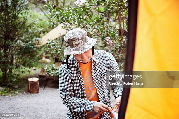 a man camping in the mountain - picchetto da tenda foto e immagini stock