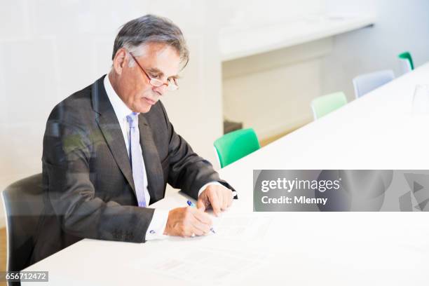 senior-unternehmer signieren von dokumenten in modernen konferenzraum - notar stock-fotos und bilder