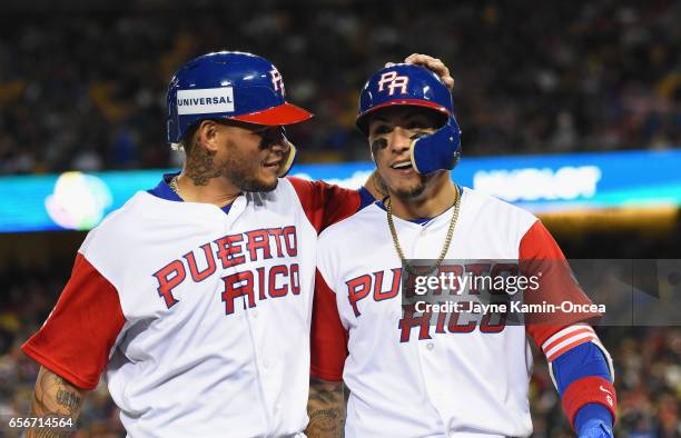 Yadier Molina and Javier Baez of team Puerto Rico walk into the dugout after both being out on a double play in the eighth inning against the United...