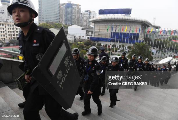 Chinese police with riot shields march up the steps of the Helong stadium before the World Cup football qualifying match between China and South...