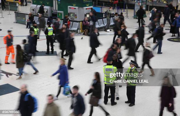 Police officers patrol during rush hour at Victoria station in central London on March 23, 2017. - Seven people have been arrested including in...