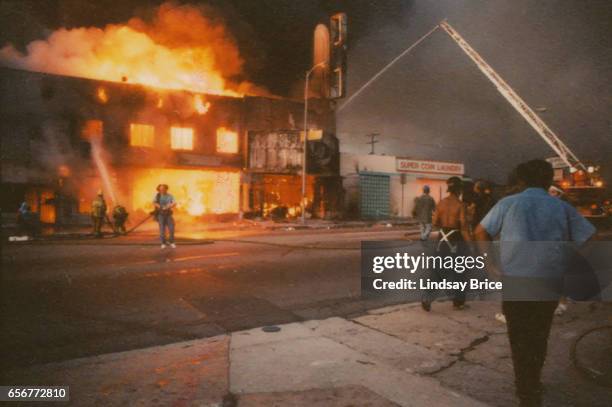 Rodney King Riot. A view of firemen attempting to put out fire of burning businesses with fire truck and crane on Pico Boulevard during the Rodney...