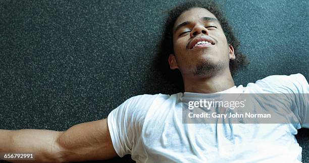 young male exhausted laying on gym floor - john hale stock pictures, royalty-free photos & images