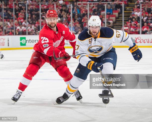 Brady Austin of the Buffalo Sabres skates up ice in front of Mike Green of the Detroit Red Wings during an NHL game at Joe Louis Arena on March 20,...