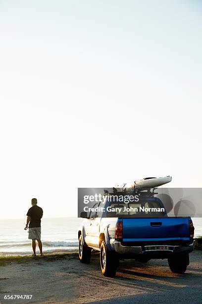 man with his paddle board on truck roof - paddle board men imagens e fotografias de stock