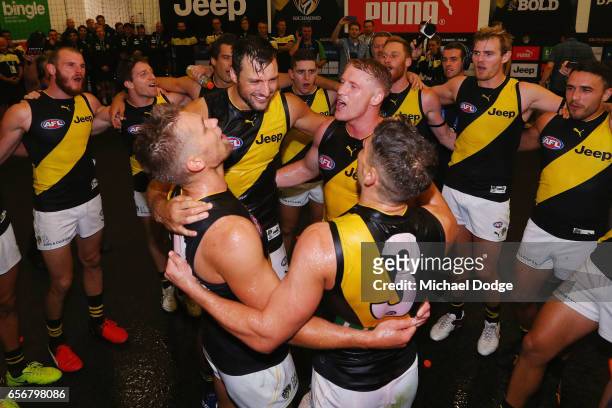 Dan Butler, Toby Nankervis, Josh Caddy and Dion Prestia of the Tigers sing the club song after winning during the round one AFL match between the...