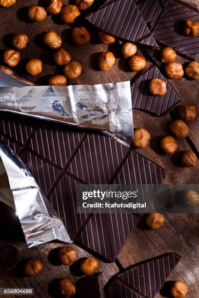 schokolade und haselnüsse auf rustikalen holztisch - chocolate foil stock-fotos und bilder