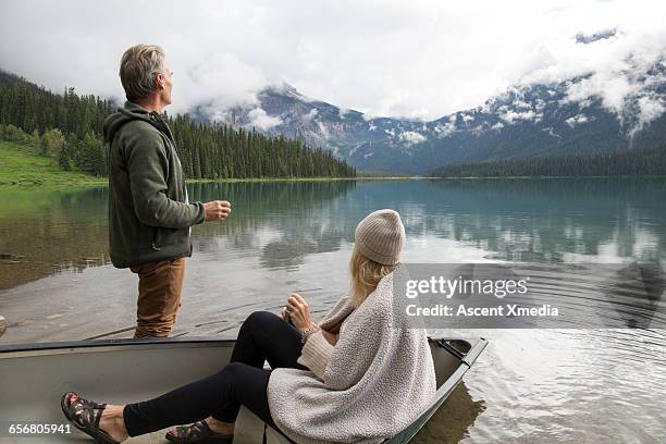 couple enjoy hot drink from canoe, mtn lake - boat top view stockfoto's en -beelden