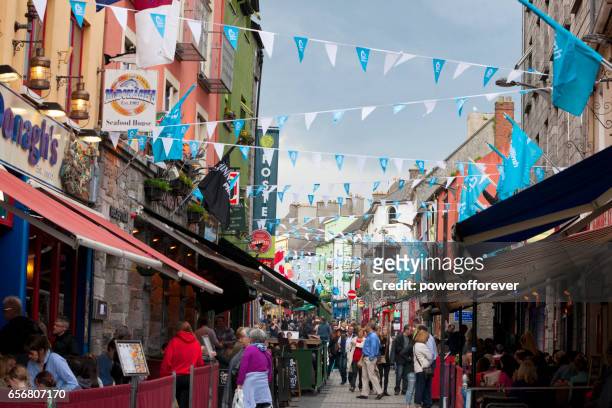 people walking along shop street in galway, ireland - galway stock pictures, royalty-free photos & images