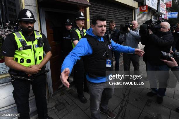 Police officers request members of the press to move away from a residential building in Birmingham which was raided by anti-terror forces in the...