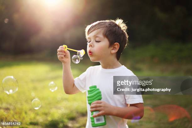 child blowing bubbles - bubble wand stock pictures, royalty-free photos & images