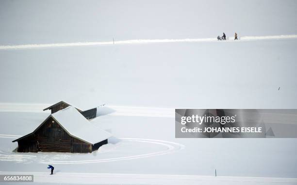 Family and a skier enjoy the snow-covered fields in Garmisch-Partenkirchen, southern Germany, on February 3, 2012. Temperatures plunged to new lows...