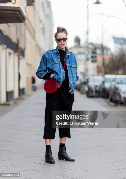 Leonie Bockelmann wearing black cropped pants, denim jacket, red bag, ankle boots on March 22, 2017 in Berlin, Germany.