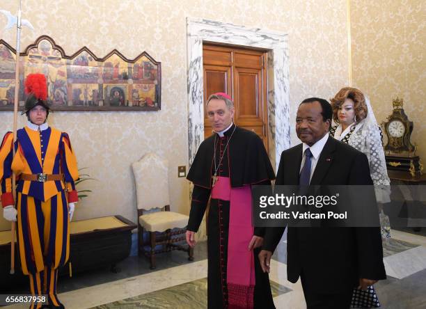 President of the Republic of Cameroon, Paul Biya and his wife Chantal Biya, flanked by the Prefect of the Pontifical House Georg Ganswein as they...