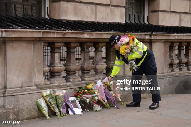 Police officer lays flowers on Whitehall around a photograph of police officer Keith Palmer who was killed in the March 22 terror attack in...