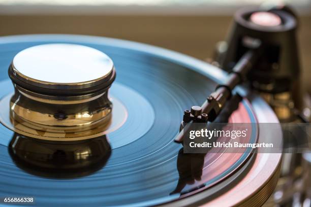 Symbol photo on the theme Renaissance of the records . The photo shows the detail of a record player with tone arm and a record.