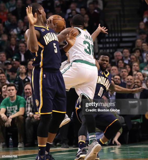 Boston Celtics guard Marcus Smart puts up an off balance shot as he is fouled by Indiana Pacers guard Aaron Brooks for the three point play to give...