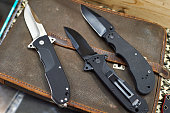 Folding knives on leather retro bag tablet in rarity store