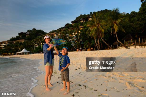 mom and son playing bubbles on the beach - boracay philippines stock pictures, royalty-free photos & images