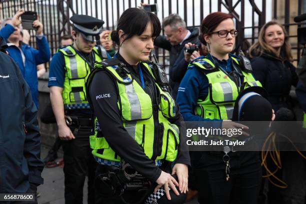 British Transport Police officers pause after laying floral tributes on Westminster Bridge following yesterday's attack in which one police officer...