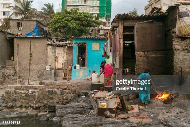 familia preparando comida en barrio frente a la playa, mumbai, india - indian slums fotografías e imágenes de stock