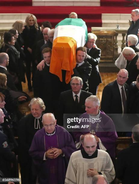 Martin McGuinness's sons Emmet and Fiachra , carry the coffin out of St Columba's Church Long Tower after the funeral of former Northern Ireland...