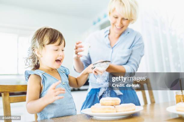 mother and daughter making sweet donuts in the kitchen - sugar glider stock pictures, royalty-free photos & images