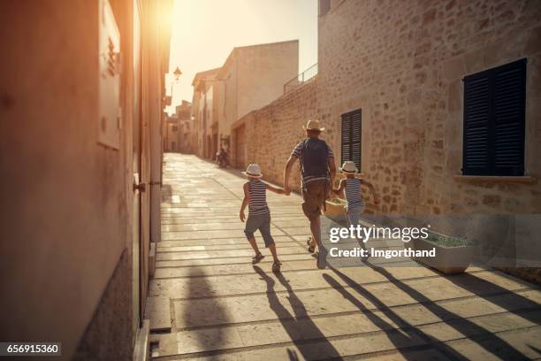 father with two sons visiting mediterranean town. - weekender stock pictures, royalty-free photos & images