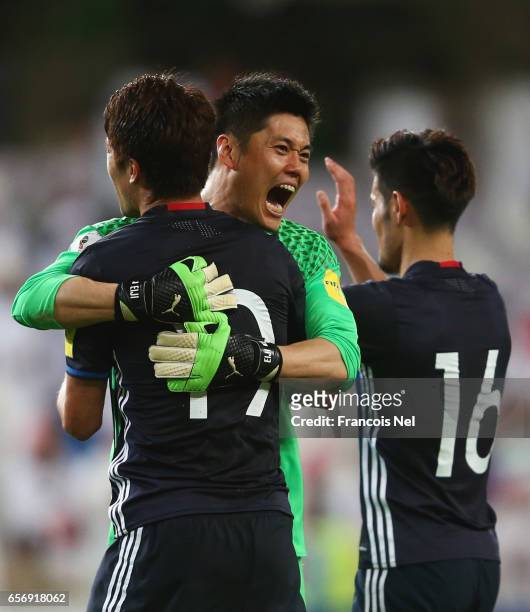 Eiji Kawashima of Japan celebrates victory with Hiroki Sakai and Hotaru Yamaguchi of Japan after the FIFA 2018 World Cup qualifying match between...